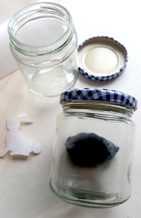 Holding a jar steady with a putty rubber or white tac 